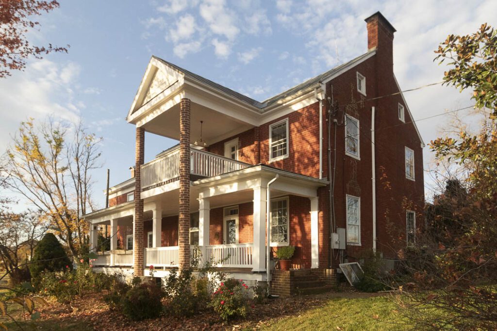 Historic home with porch protruding.