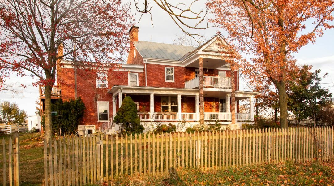 Front of historic porch addition. Trees changing color into fall.